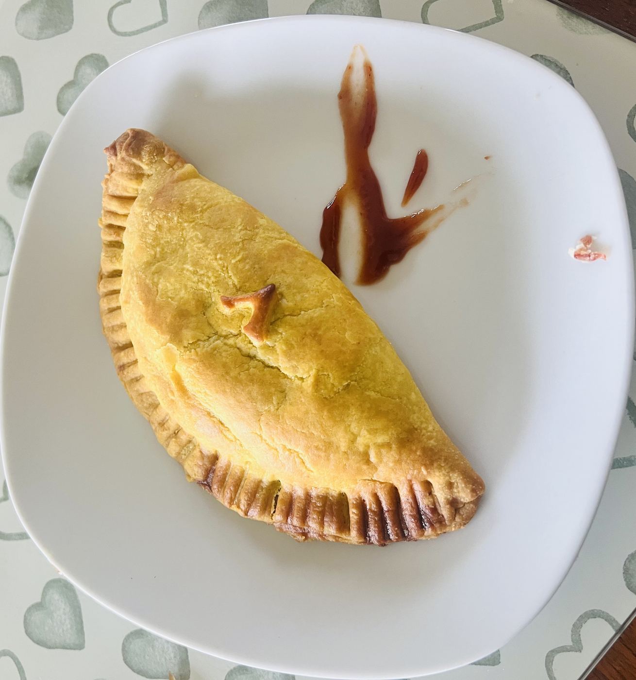 Golden home-baked patty with a Z pressed into the crust, served with sauce