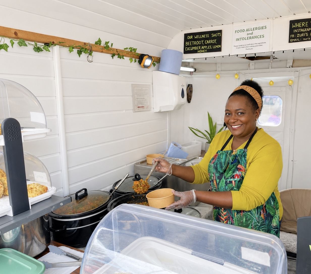 Zuri smiling in the mobile canteen, serving a bowl from the pot